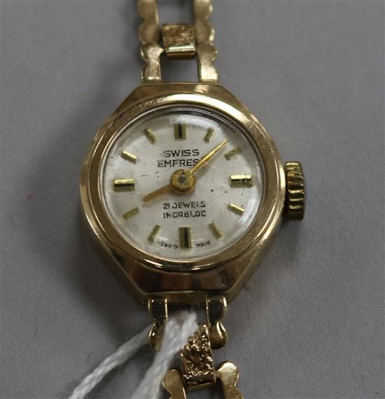 A ladys 9ct gold Swiss Empire manual wind wrist watch on a 9ct gold bracelet.